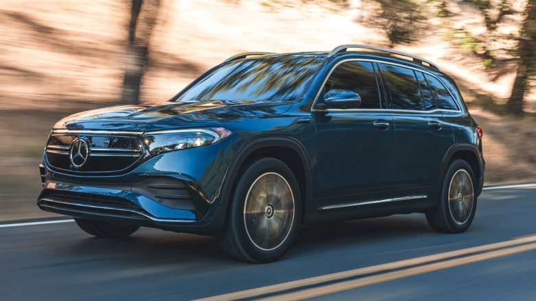 <p>Camioneta Mercedes Benz EQB familiar color azul siendo conducida por autopista con fondo de árboles.</p>