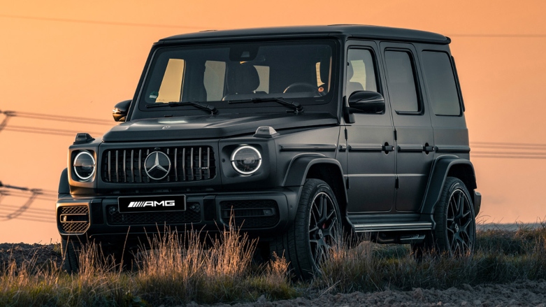 Mercedes AMG Clase G 4x4 con sistema 4Matic estacionada en terreno desolado con fondo de atardecer.