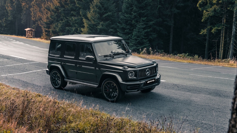 Carro de alta gama Mercedes-AMG Clase G Color negra siendo conducida por carretera.